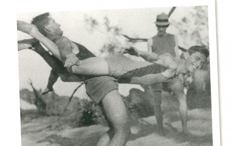 Old photo of three men horsing around in old bathing costumes